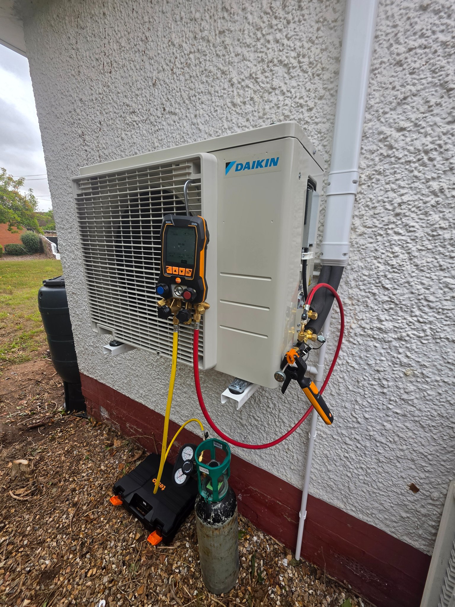 Digital manifold gauges connected to the outdoor unit while commissioning an air conditioning installation in North Petherton