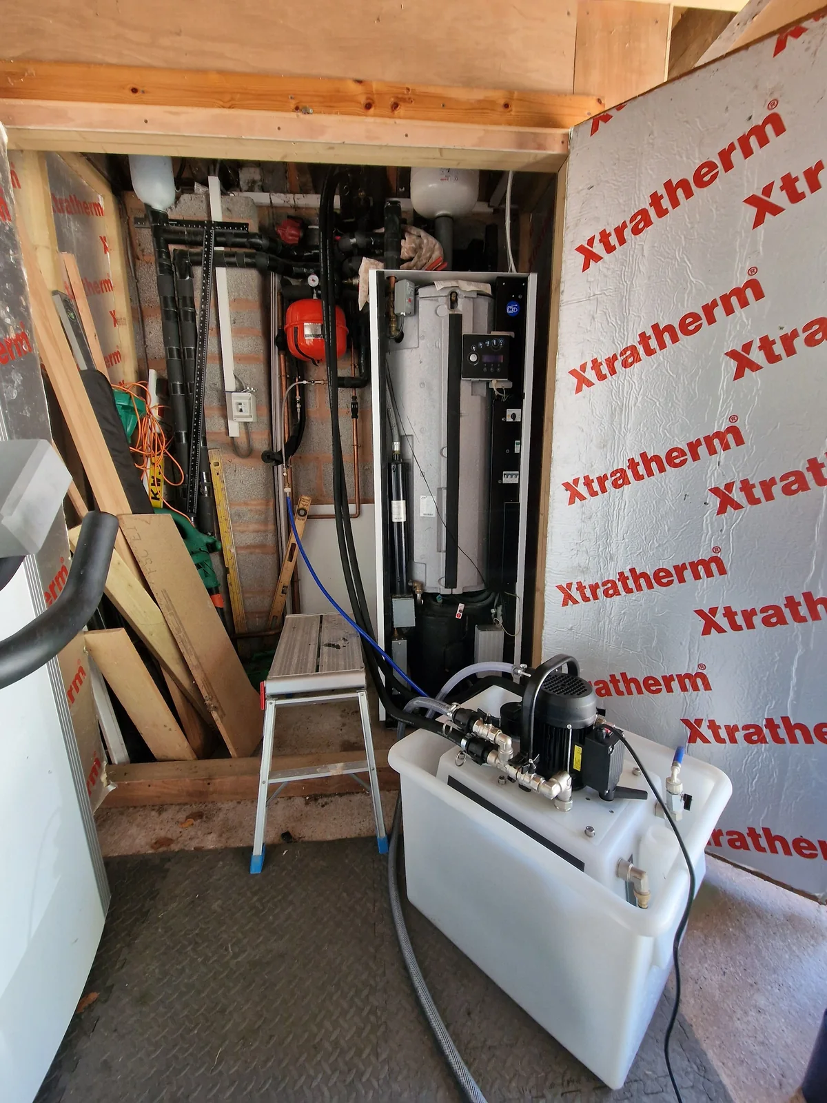 Power-flushing rig connected into a plant-room heat pump and cylinder installation