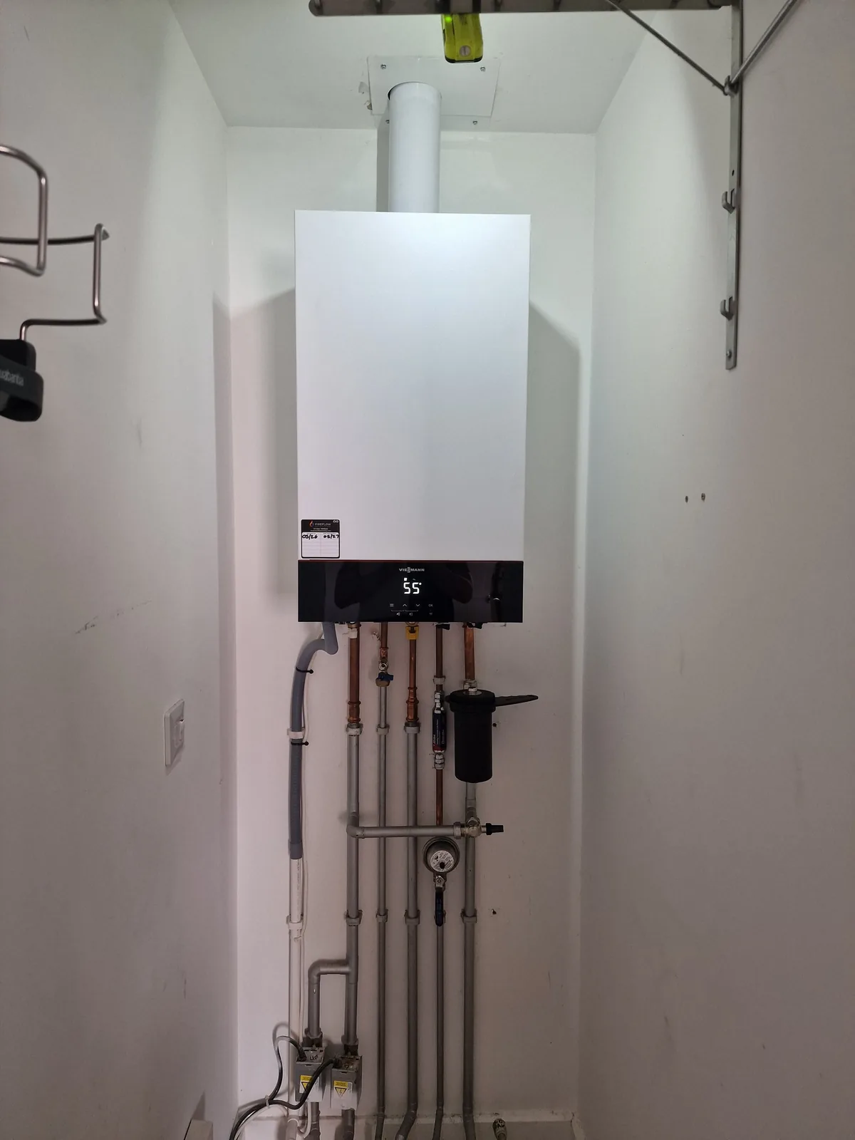 Close-up of the new Viessmann combi boiler flueing and pipework after commissioning