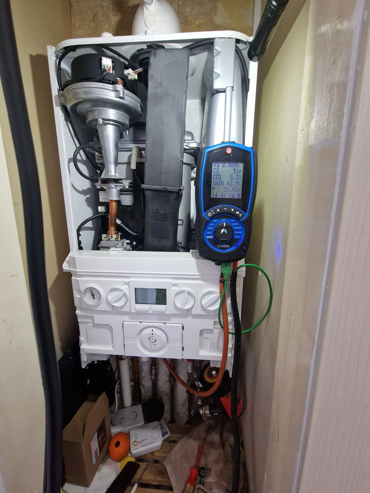 Baxi boiler opened up during a service with flue gas analyser attached to check combustion